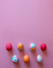 Happy Easter holiday! Colorful hand-painted Easter eggs in a decorative nest on pink background.