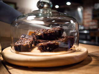 portions de brownies individuelles sous une cloche en verre
