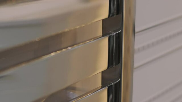 Closeup heated towel rail, dryer in bathroom, metal pipes, metal batteries