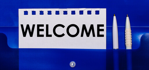 On a blue background, white pens and a sheet of paper with the text WELCOME © Елена Дигилевич