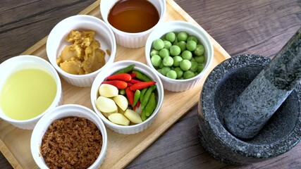 Top view of shrimp paste ingredient and stone mortar to make Spicy Shrimp Paste Chili Sauce, favorite Thai food (Nam Prik Ka Pi)