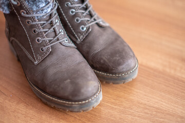Close up of a pair of women's brown ankle boots on a wooden floor