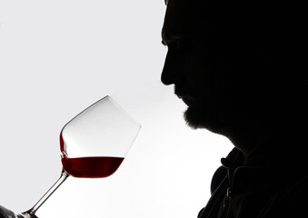 silhouette of a sommelier tasting an excellent red wine