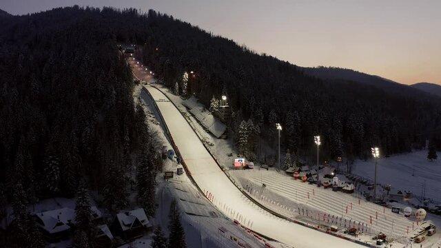 Empty ski jumping of Zakopane in Poland illuminated at twilight. Aerial rising