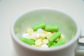 Pills in a mug, pills in a mug on a white background