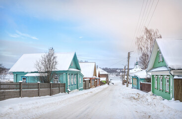 Fototapeta na wymiar Wooden houses on Nikolskaya Street and a view of the frozen Volga in Plyos