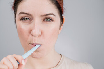 Close-up portrait of caucasian woman brushing her teeth. The girl performs the morning oral hygiene procedure
