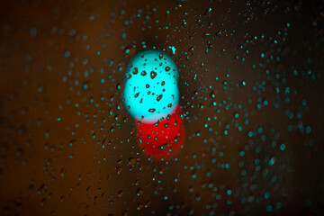 blurry background with raindrops and red and blue lights in center