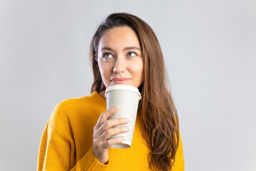 Young woman drinking coffee from paper cup