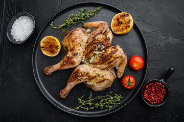 Grilled whole chicken, with chimichurri sauce, on black background, top view
