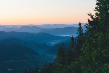 Dawn in the mountains. Beautiful landscape of morning hills in the fog