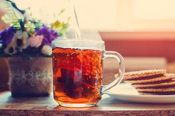 To make tea. Pour tea into a glass.