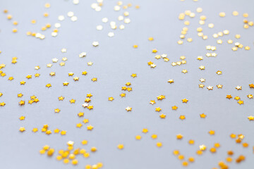 Obraz na płótnie Canvas Golden shiny stars glitter or confetti on gray background