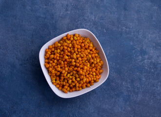 fresh orange buckthorn in a white bowl on blue background