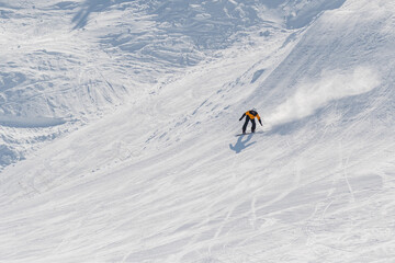 Naklejka na ściany i meble Snowboarder slides down the mountainside 