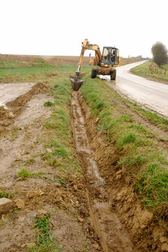 Lutte contre les inondations et l'érosion des sols. Construction d'un fossé en bordure d'un champ en pente pour l'évacuation des eaux de ruissellement