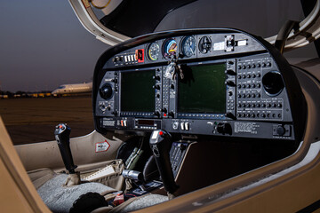 open small private cockpit jet in sunset control panel