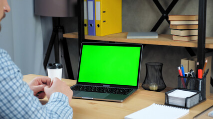 Green screen mock up chroma key display monitor laptop computer concept: Businessman at home office...