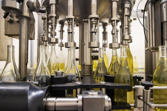 White wine bottled at winery in bottling conveyer machine