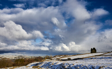 Late afternoon, and a light snowfall highlights the abandoned quarry spoil heaps in Yorkshire