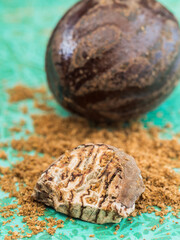 Closeup of aromatic nutmeg on on a turquoise background.