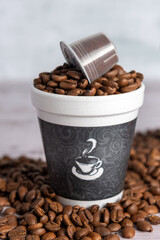 Distintos tipos de cafe, crudo, tostado, molido y en capsulas en varios recipientes.