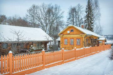 Wooden residential yellow house and a fence on Nikolskaya Street in Plyos