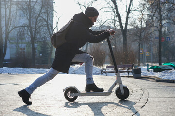 guy rides an electric scooter in the park