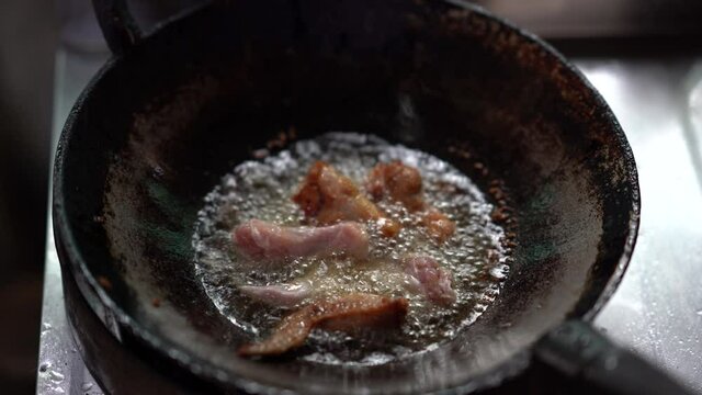 chicken meat cooking in hot oil on pan, unhealthy of fatty to people, splash and droplet of oil danger, gas fuel burnning to heat for fried or roast meat, raw fried chicken drumstick menu of delicious