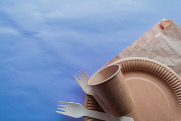 Disposable environmentally friendly food packaging. Food containers made of brown kraft paper on lilac background. Top view, flat lay.
