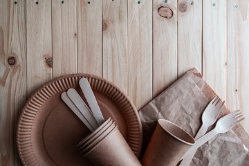 Fototapeta na wymiar Disposable eco friendly food packaging. Brown kraft paper food containers on wooden background. Flat lay.