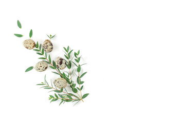 Easter decor with natural quail eggs and eucalyptus leaves.