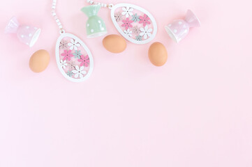 Easter decor on pink background. Pastel eggs and egg holders table decoration .