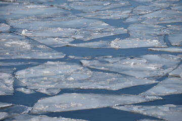 Fototapeta na wymiar Ice drift on river in early spring on sunny day