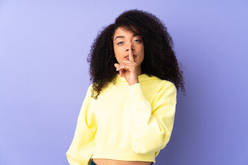 Young african american woman isolated on purple background showing a sign of silence gesture putting finger in mouth