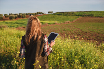 Female field engineer using a digital tablet in agricultural plantation. Integration of women in the field, agriculture and happy women concepts