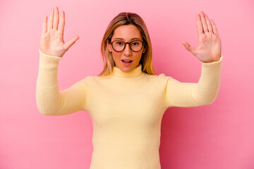 Young mixed race woman isolated on pink background receiving a pleasant surprise, excited and...
