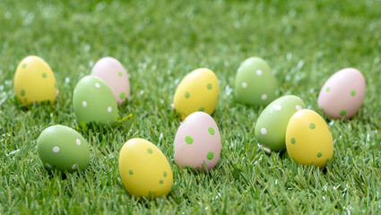 Fototapeta na wymiar Happy Easter. Pastel colored eggs on green grass, close up view
