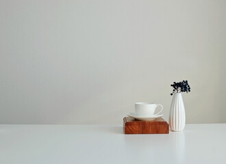 A white cup and saucer and a vase. Stylish interior mockup, copy space.
