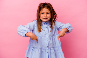 Little caucasian girl isolated on pink background  points down with fingers, positive feeling.