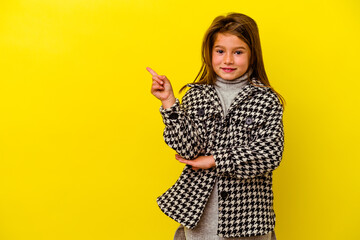 Little caucasian girl isolated on yellow background smiling cheerfully pointing with forefinger...