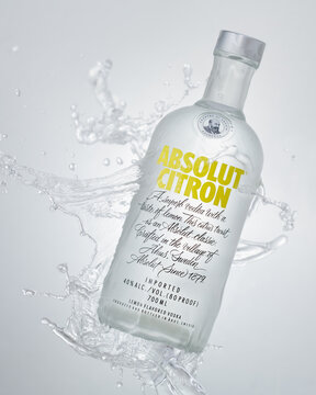 Absolut Vodka in Citron version in a studio shot with splash to invoke a refreshing drink.