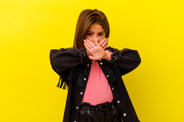 Little caucasian girl isolated on yellow background doing a denial gesture