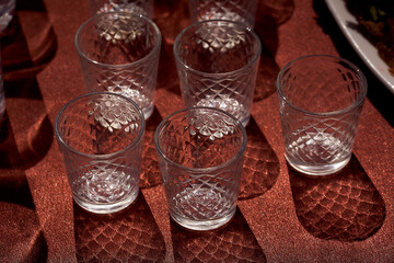 Glass glasses with a cast shadow on a brown background. Top view.