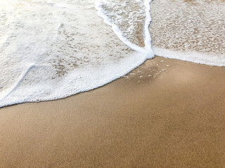 smooth waves of the sea on the sandy beach in summer