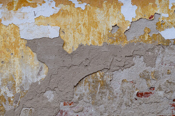 Old wall for texture or background, rough aged surface, remnants of peeling plaster, multi-colored...