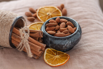 Almonds. A handful of almonds in a plate. Cinnamon and orange. Top and side view