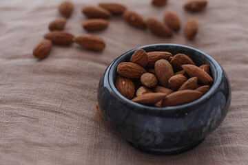 Roasted almonds. A handful of almonds in a plate. Cinnamon and orange. Top and side view