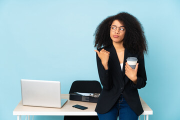 African american business woman working in her workplace unhappy and pointing to the side