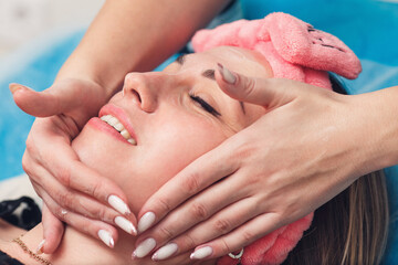 Beautician in the salon doing facial massage